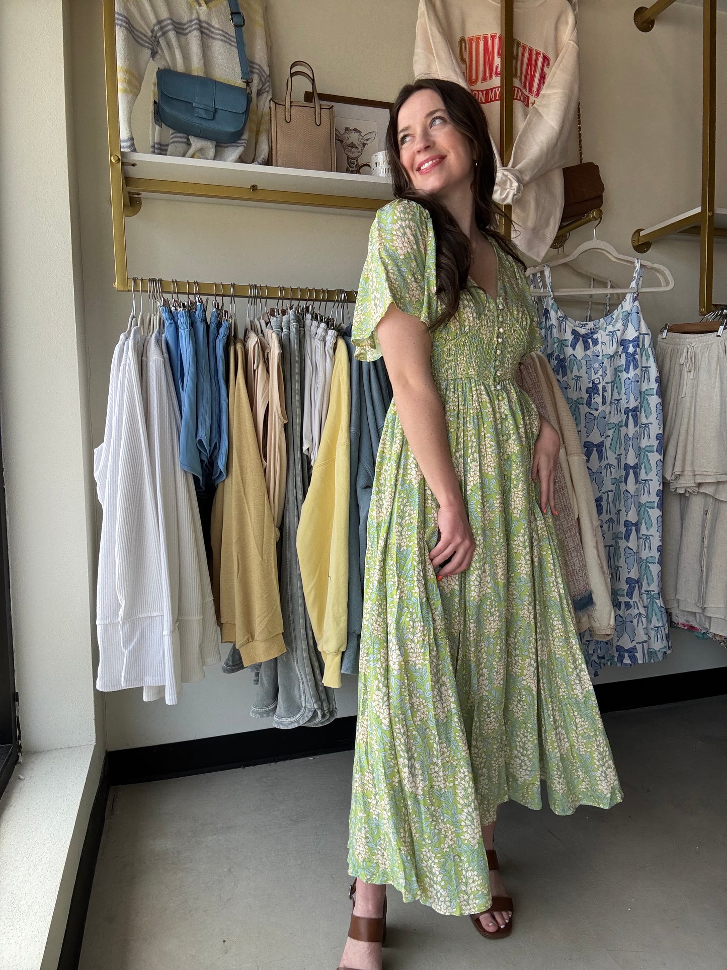 Introducing our Fern Smocked Waist Button Dress, a playful revamp on our best-selling design! Made with a soft floral rayon fabric, this maxi dress features a flattering smocked waist, functional cover buttons, and elastic exaggerated sleeves. With raglan sleeves, a v neckline, and side pockets, this dress offers both style and convenience.