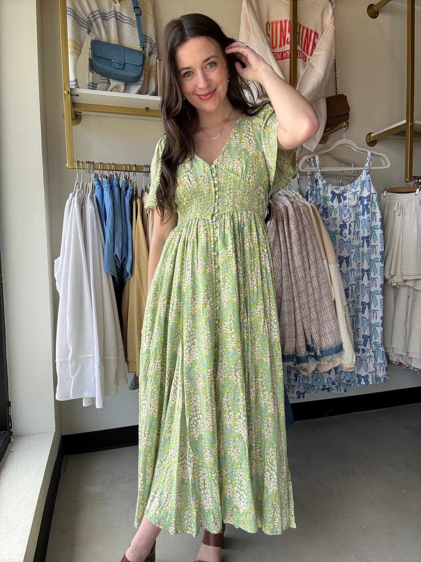 Introducing our Fern Smocked Waist Button Dress, a playful revamp on our best-selling design! Made with a soft floral rayon fabric, this maxi dress features a flattering smocked waist, functional cover buttons, and elastic exaggerated sleeves. With raglan sleeves, a v neckline, and side pockets, this dress offers both style and convenience.