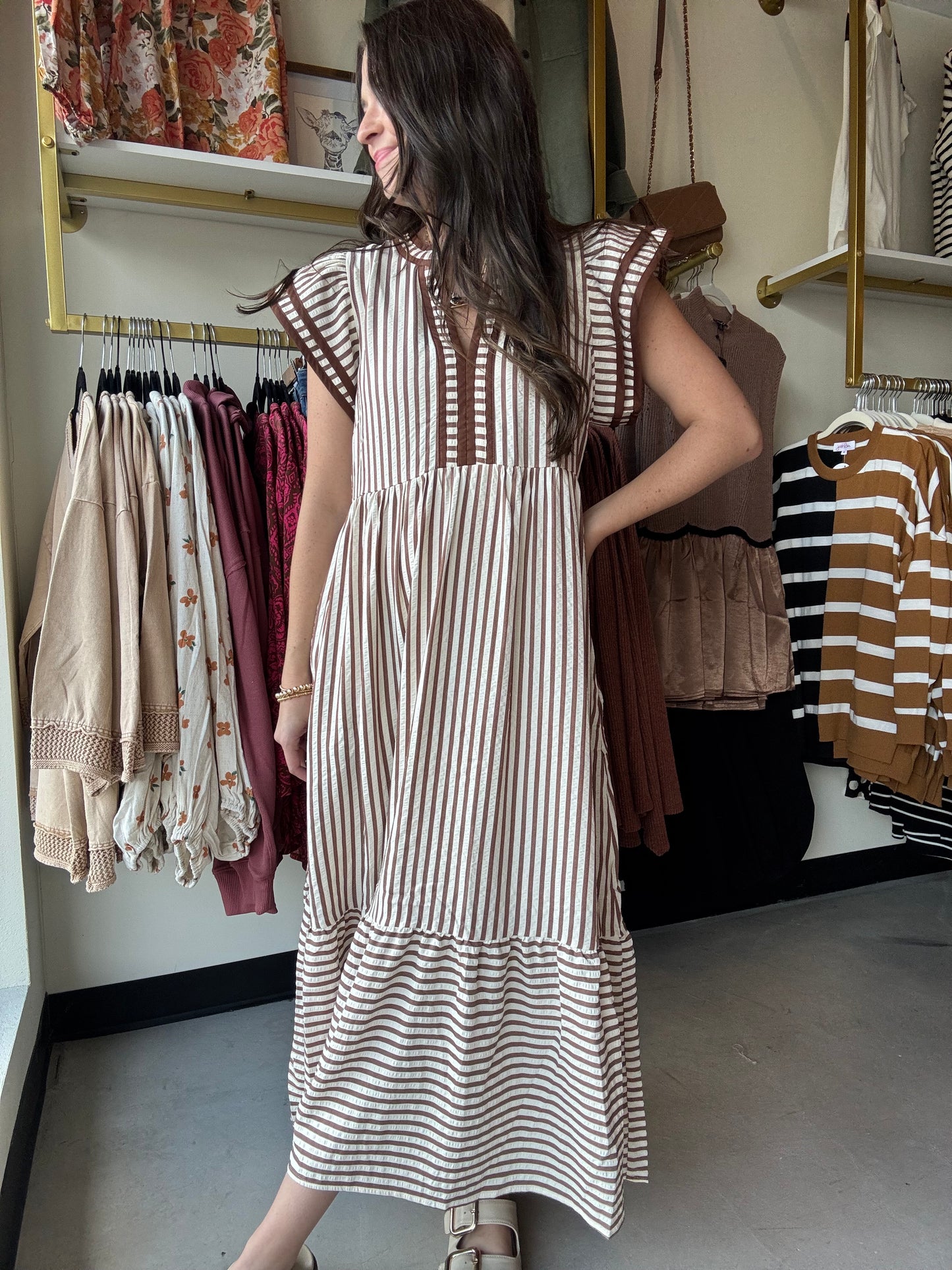 This brown cap sleeve dress features a textured striped pattern enhanced by tiered ruffle flutter sleeves with contrast accent binding detail for a refined look. Crafted from lightweight woven fabric, it offers a comfortable, non-sheer feel and includes convenient side pockets. Fully lined for added comfort and modesty, this dress combines style and functionality with expert design elements.
Entro
