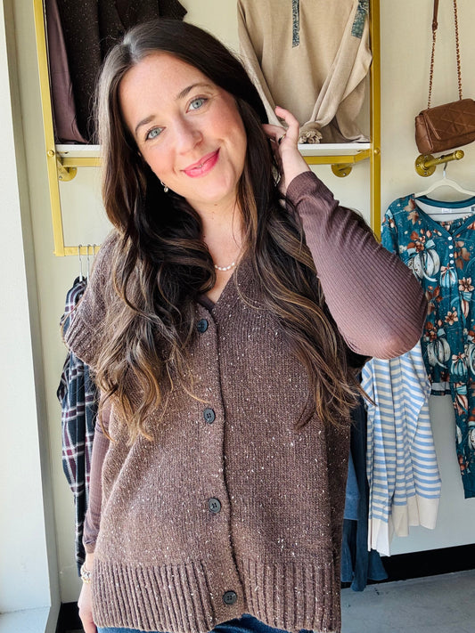 Mustard Seed 
Get cozy and cute with this Dark Chocolate Sweater Vest! Featuring functioning buttons and playful cap sleeves, it’s perfect for layering any outfit. The ribbed detailing adds a fun texture twist while keeping things comfy and stylish. Perfect for when you want a little warmth with a lot of charm.