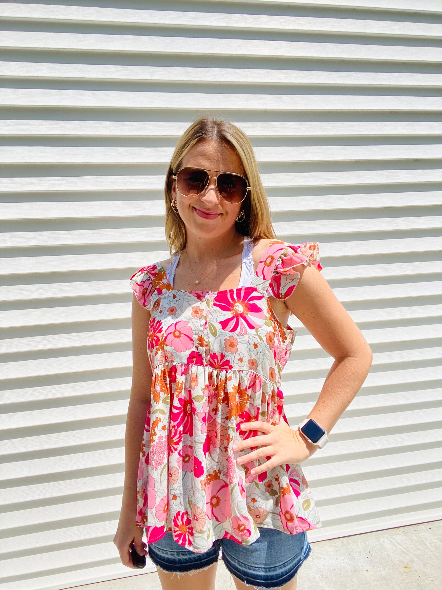 This Shades of Pink Floral Top is the perfect addition to your summer wardrobe. Its high neckline and flutter sleeve are perfect for sunny days, while the bright colors and peplum top add an extra touch of style. Accessorize to create a look that is all your own.