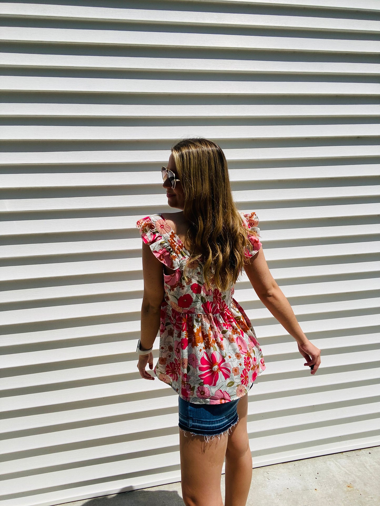 This Shades of Pink Floral Top is the perfect addition to your summer wardrobe. Its high neckline and flutter sleeve are perfect for sunny days, while the bright colors and peplum top add an extra touch of style. Accessorize to create a look that is all your own.