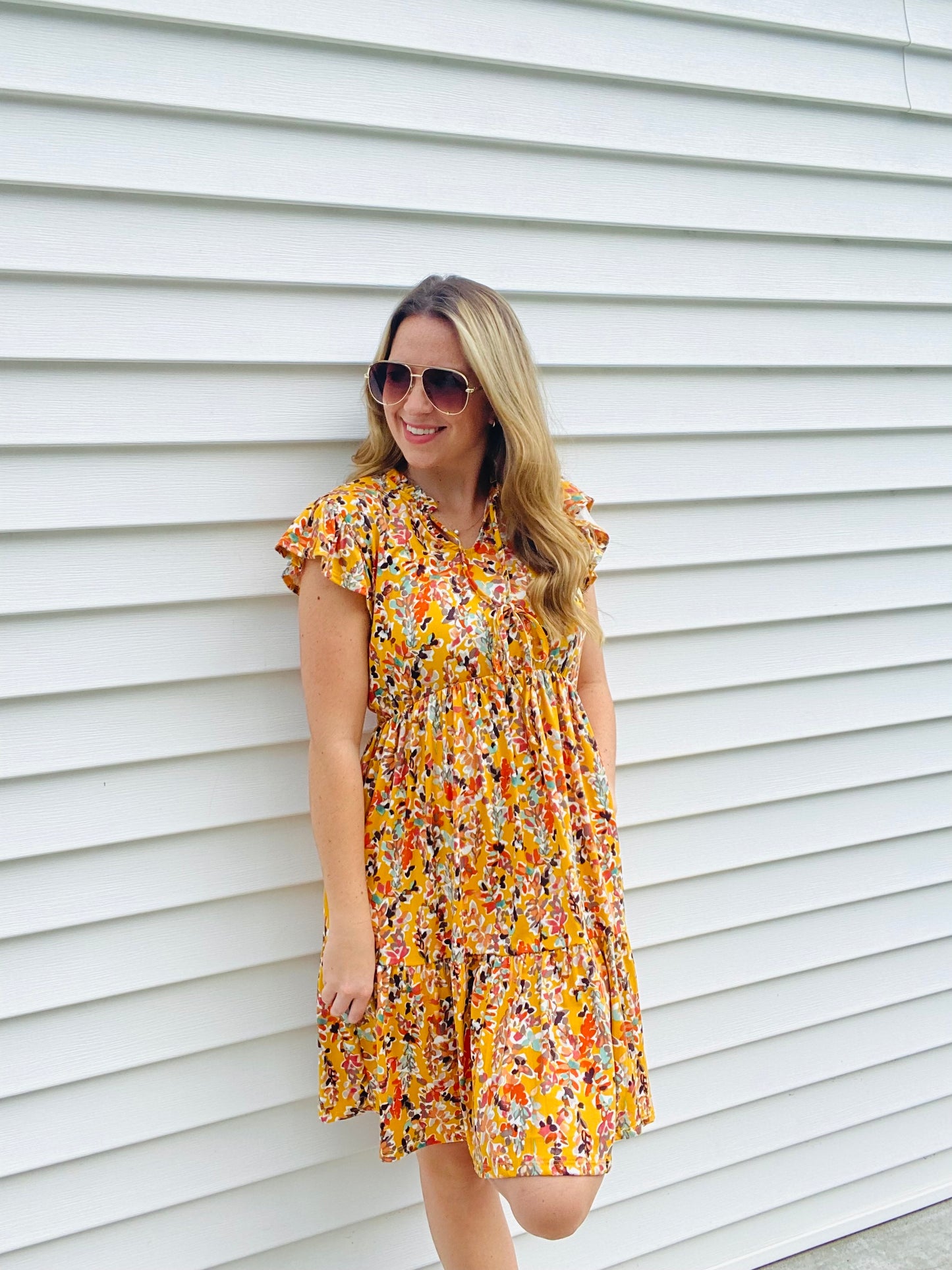 This Honey Ruffle Floral Dress is perfect for any occassion. Boasting beautiful features such as a v-keyhole neck with string-tied ruffle frill, a babydoll fit and flare silhouette, and tiered ruffle hem, this dress offers a flattering and elegant look. The vibrant multicolor floral print knit pairs perfectly with the side pockets for a practical and stylish dress.