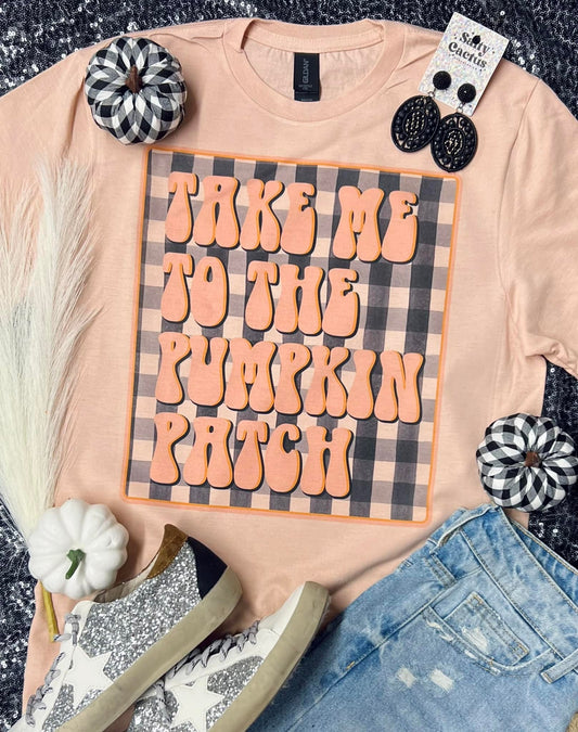 T-shirt with 'Take me to the pumpkin patch' design on a checkered background, surrounded by Halloween-themed accessories.