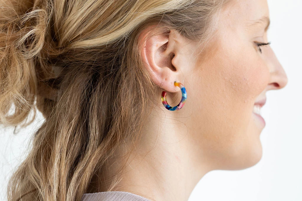 Cam is a mini sized hoop. These ultra lightweight hoops are simple and classic. The perfect versatile piece for everyday wear! Hypoallergenic stainless steel Lightweight and durable plant-based acetate acrylic 1" diameter Each pair will vary in coloring, making them perfectly unique