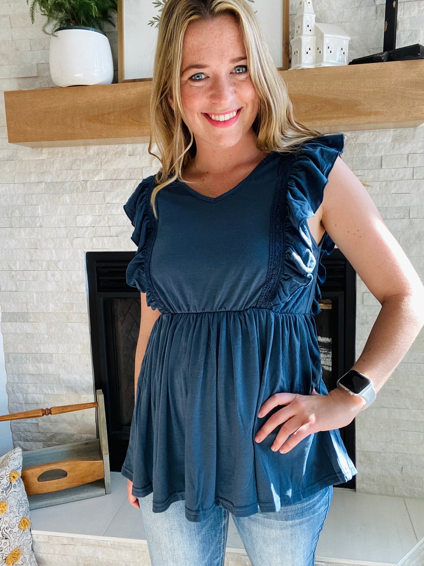 Look fashionable and feel confident wearing this navy ruched peplum tank top. The flattering silhouette is perfect for pairing with light or white denim. Flutter accents add a touch of femininity to the design. It's a great choice for any occasion.