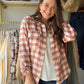 Model wearing a terracotta and ivory plaid button-up shirt open over an ivory top with jeans.