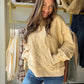 Model wearing a dandelion yellow quilted quarter-zip hoodie with a drawstring hood and kangaroo pocket.