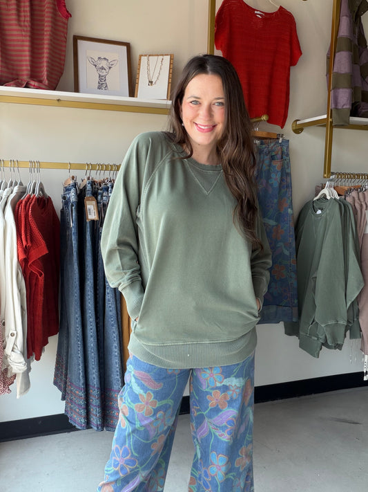 Soft, slouchy, and seriously cozy. The&nbsp;Army Green Pigment Dyed Pullover by Zenana is your new favorite weekend essential. Made from 100% cotton French terry, it has that perfectly worn-in feel with a pigment dye finish that gives it a subtle, vintage-inspired depth of color unique to each piece.

Ribbed detailing adds a polished touch, and the handy pockets make it as practical as it is stylish. Whether you're running errands or lounging at home, this relaxed pullover does it all in effortless dusty bl
