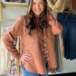 Model wearing a rust-brown Raw Umber French terry shacket open over a floral top with jeans.