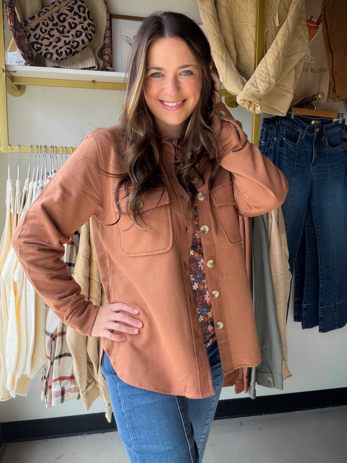 Model wearing a rust-brown Raw Umber French terry shacket open over a floral top with jeans.