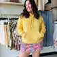 Brighten your wardrobe and your mood with this sunshine-inspired staple. Featuring a cloud-like fleece lining and a classic kangaroo pocket, it’s the ultimate blend of effortless style and premium warmth. Perfect for layering on chilly mornings or lounging in total comfort.