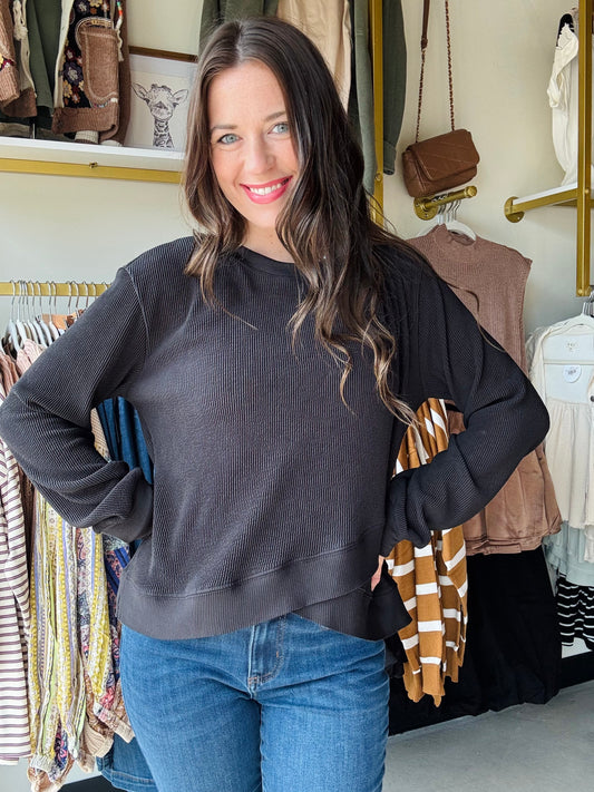 Umgee

This black long sleeve pullover features an expert design with an asymmetrical layered hemline that adds a modern edge to your wardrobe. The classic crewneck offers a clean, versatile look, while the unlined construction ensures lightweight comfort and easy layering. Perfect for those seeking a sophisticated yet contemporary top.