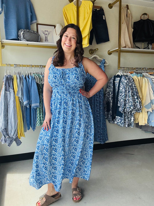 Staccato

Radiate summer elegance in this stunning blue floral maxi, featuring a flattering smocked bodice and breezy double-scoop neckline. Fully lined and effortlessly sleeveless, it’s the ultimate choice for sun-drenched brunch dates or coastal getaways.

Flattering smocked bodice hugs your curves.
Breezy sleeveless cut for hot days.
Elegant double-scoop neck adds sophistication.
Fully lined for confident, worry-free wear.
Flowy maxi length offers effortless movement.
Vibrant floral print for timeless st
