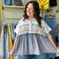 Oli &amp; Hali

Elevate your wardrobe with this eclectic Oli &amp; Hali mixed-media top, featuring a vibrant woven yoke and a soft mineral-washed babydoll hem. Effortlessly chic and relaxed, it’s the perfect blend of boho-luxe comfort and playful, artistic detail.

Signature Oli &amp; Hali quality craft.
Vibrant hand-woven chevron yoke detail.
Flattering relaxed babydoll silhouette.
Edgy mineral-washed textured fabric.
Playful smiley patch back detail.
Chic collared button-down placket.
Comfortable true-to-