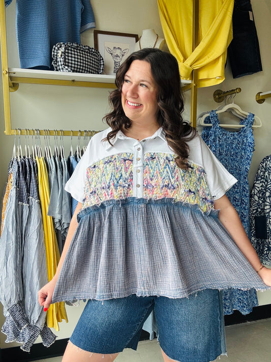 Oli &amp; Hali

Elevate your wardrobe with this eclectic Oli &amp; Hali mixed-media top, featuring a vibrant woven yoke and a soft mineral-washed babydoll hem. Effortlessly chic and relaxed, it’s the perfect blend of boho-luxe comfort and playful, artistic detail.

Signature Oli &amp; Hali quality craft.
Vibrant hand-woven chevron yoke detail.
Flattering relaxed babydoll silhouette.
Edgy mineral-washed textured fabric.
Playful smiley patch back detail.
Chic collared button-down placket.
Comfortable true-to-