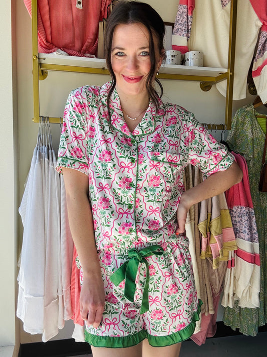 Jess Lea
Lounge in style with our Botanical Garden Ruffle Pajama Set. Featuring a beautiful hydrangea print, button up top, and playful ruffle shorts with a decorative tie. Get ready for a comfortable and fun night's sleep!