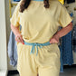 Anniewear

Brighten your downtime with these cloud-soft lounge shorts featuring a sunny yellow stripe and a contrasting sky-blue waistband. Designed for ultimate relaxation, these breezy shorts combine a functional drawstring fit with essential side pockets. Complete the look with the matching top for your new favorite weekend uniform.

Ultra-soft butter-yellow ribbed fabric.
Contrasting sky-blue elastic drawstring waist.
Functional side pockets for essentials.
Relaxed fit for all-day comfort.
Pairs perfect