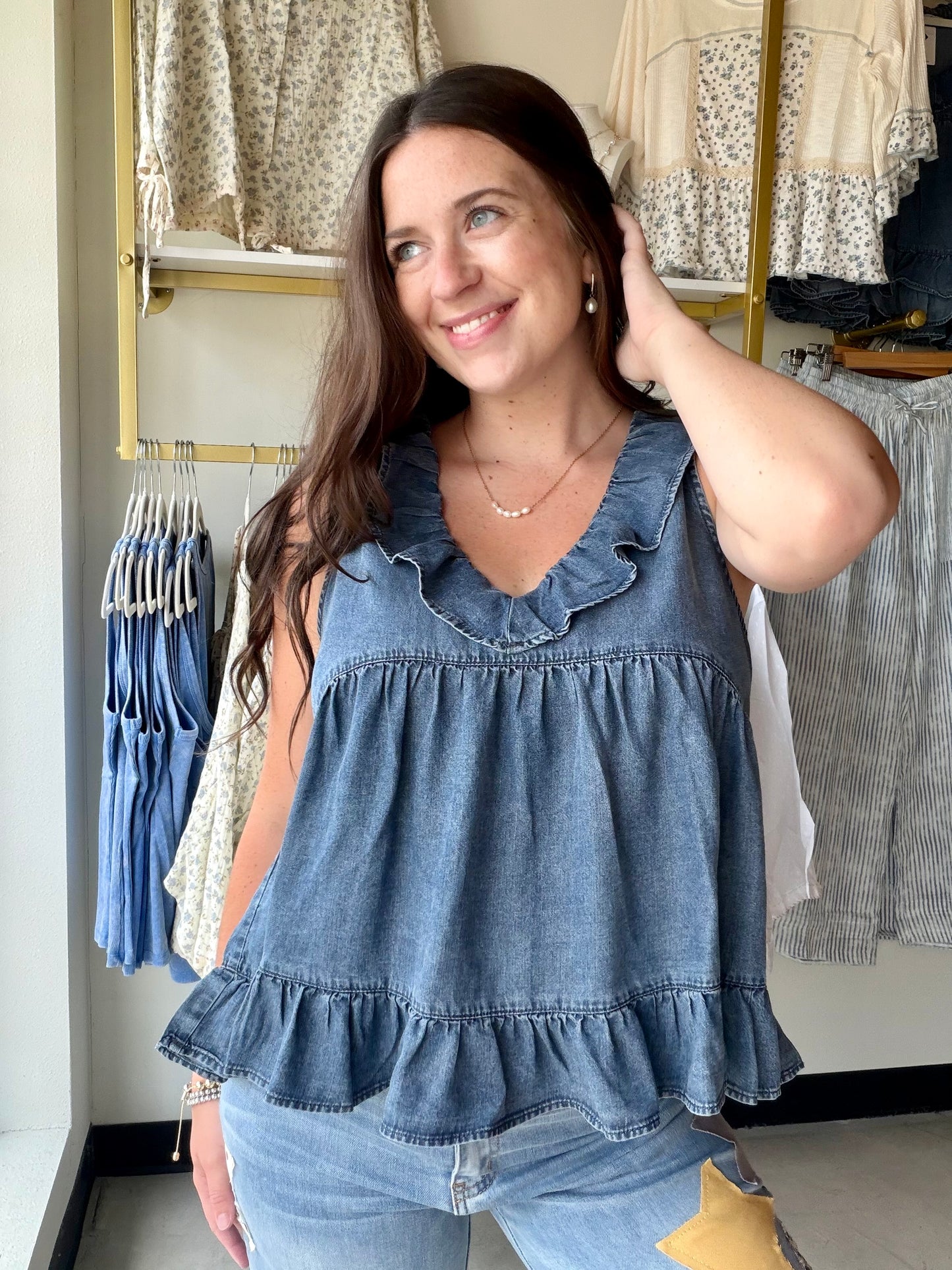 Effortless femininity, no effort required. The Dark Chambray Ruffle Tank is the kind of warm-weather piece that looks like you tried — without actually trying at all.

A ruffled V-neckline and flirty tiered babydoll silhouette give it that soft, romantic energy, while the lightweight chambray fabric keeps things cool and breezy from morning to evening. The ruffled hem adds movement with every step, making this one just as good for a weekend brunch as it is for a summer evening out.

Wear it alone, tuck the 