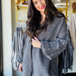 Umgee

Wrap yourself in cozy charm with the Charcoal Pearl Sleeve Cardigan. This playful open-front piece features delicate pearl buttons and long sleeves that add a touch of elegance to your everyday look. Perfect for layering, it effortlessly blends comfort with style, making it your new go-to for cooler days and casual outings.