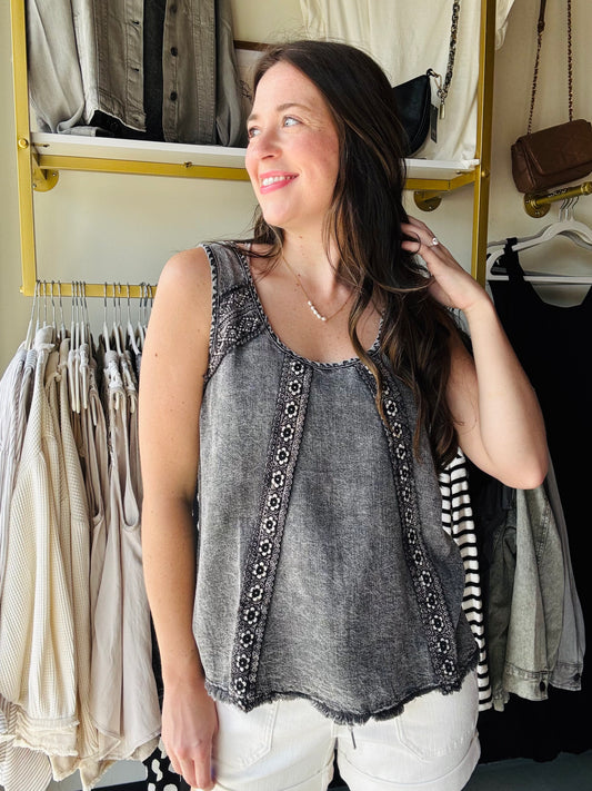 Experience ultimate comfort with our Washed Charcoal Tencel Tank, crafted from super soft Tencel fabric that feels like a gentle hug. Its scoop neckline adds a flirty touch, while delicate floral embroidery brings a splash of charm to your everyday look. Perfect for sunny days or layering up with your favorite jacket!