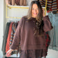 A Little Romance for Your Everyday Wardrobe

Rich chocolate brown meets delicate lace in this Anniewear sweater, giving an everyday knit a beautifully feminine finish. The simple sweater silhouette lets the details shine: ribbed edges, roomy-looking sleeves, and a wide band of floral lace extending below the hem.

It is an easy choice for those days when you want something more dressed up than a basic sweater without putting together a complicated outfit. Think lunch with friends, dinner plans, or a fall af