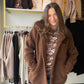 Bring a little cozy charm to your outerwear lineup with the Chocolate Brown Teddy Jacket by Michelle Mae. Its teddy-inspired style and rich chocolate brown color give everyday outfits a welcoming, seasonal feel, while a fleece-lined interior adds an extra cozy touch. It’s a lovely finishing layer for denim days, casual outings, and all those moments when you want your outfit to feel as inviting as your plans.

Picture a crisp afternoon, a warm drink in hand, and a little time to wander your favorite shops. 