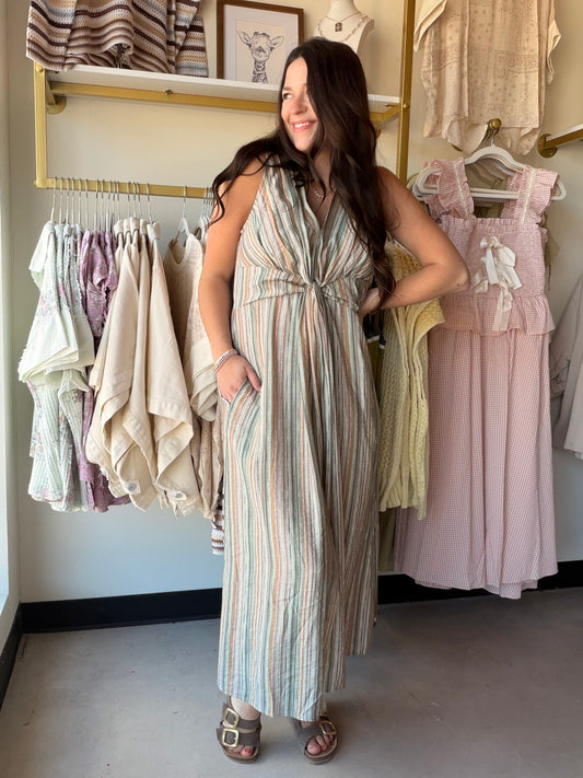 Cozy Co.

Embrace effortless warm-weather style with this sleeveless midi dress. Designed with a flattering V-neckline and a chic front-twist detail at the waist, it creates beautiful draping down the skirt. The vertical striped pattern elongates the silhouette, while practical side pockets add a casual, functional touch. Perfect for resort getaways or weekend brunches.