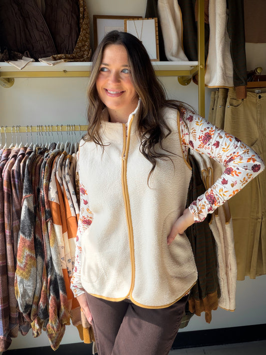 Soft, cozy, and effortlessly chic. The Cream Sherpa Accent Vest by Creation is the layering piece your fall and winter wardrobe has been waiting for.

Featuring plush sherpa accents in a warm cream tone, this vest adds instant texture and dimension to any look. Style it over a fitted long-sleeve, a flannel, or your favorite denim for a cozy-meets-polished vibe that works from errands to evenings out.

Sherpa accent detailing
Sleeveless silhouette
100% Polyester
Available in sizes S–XXL
Sophie is wearing the