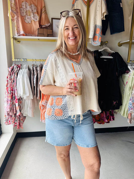 Embrace effortless boho vibes with this Oli &amp; Hali mineral wash top, featuring intricate orange floral crochet accents and a breezy V-neck. Crafted from 100% breathable cotton, this relaxed-fit tee blends vintage texture with modern comfort for the ultimate boutique look.

Intricate orange floral crochet details.
Soft 100% cotton breathable fabric.
Relaxed fit for effortless comfort.
Vintage-inspired mineral wash finish.
Flattering V-neck short sleeve design.
True-to-size fit for every body.
Boutique-qu