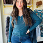Embrace cozy charm with this Dark Teal Button V Neck! Featuring a flattering V-neckline and two cute buttons, its ribbed texture adds playful detail. The long sleeves and relaxed fitted silhouette make it perfect for layering or solo style moments. Imported for a unique touch, this top pairs effortlessly with your favorite jeans or skirts for an easygoing, fun vibe.

Yelete