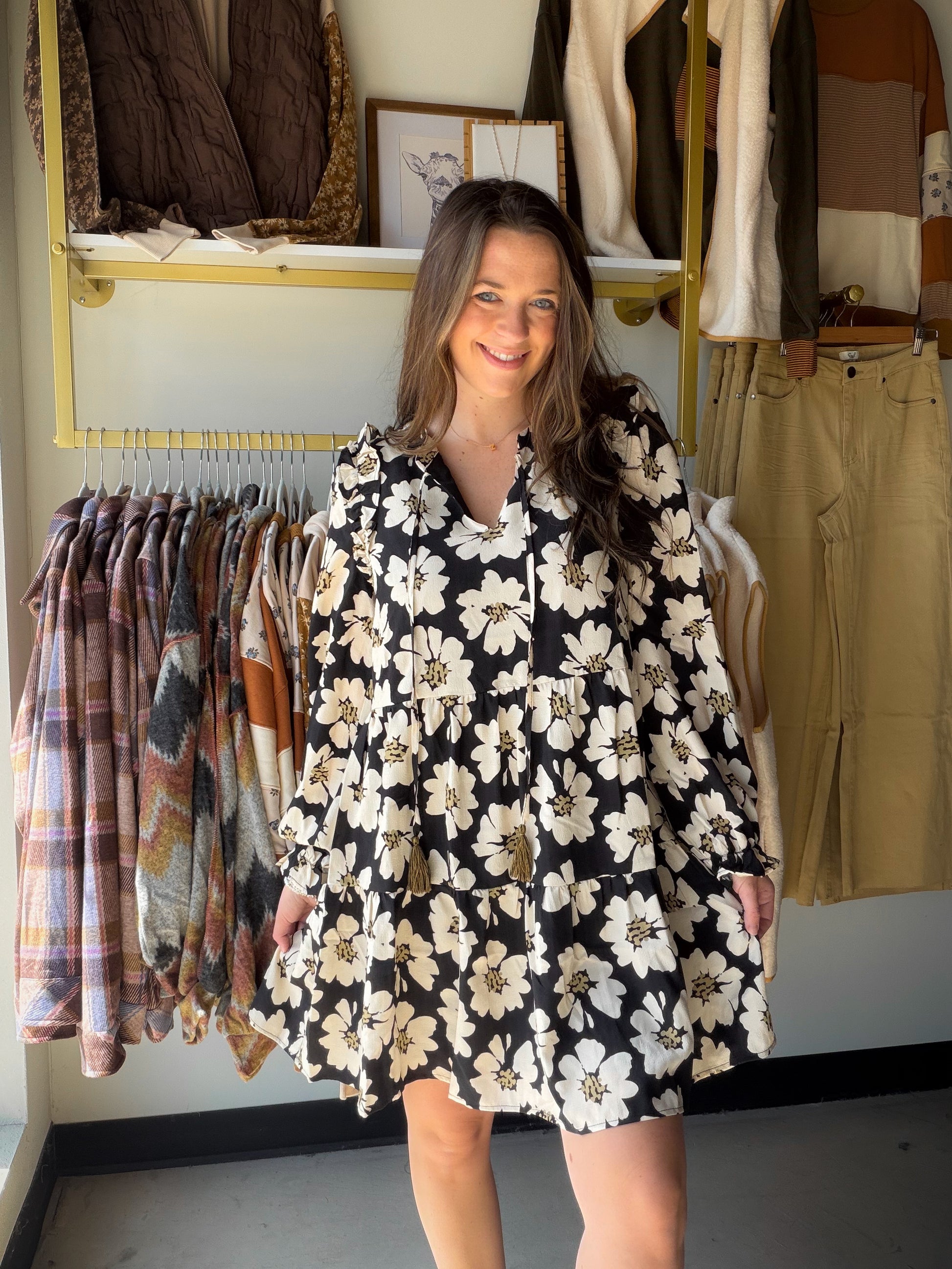 Turn heads in this dreamy floral mini from&nbsp;Doe &amp; Rae. A split V-neckline with tassel tie, long sleeves with ruffle trim, and a tiered skirt that moves beautifully — this dress does all the work for you. Wear it to brunch, a night out, or anywhere you want to feel effortlessly put-together.

Bold black &amp; white floral print with a feminine, editorial feel
Split V-neckline with tassel tie closure for a flirty, boho touch
Long sleeves with ruffle trim — elegant and season-spanning
Tiered mini skirt
