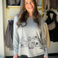 For the days when your outfit could use a little personality, reach for this grey dog sketch top from Creation. The playful graphic gives a casual long sleeve a conversation-starting touch. Pair it with denim for an easy afternoon out or layer it under a jacket when the day cools down.