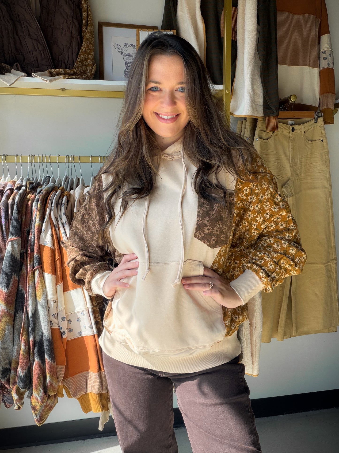 Meet your new go-to layer. The Mustard Sides Floral Accent Hoodie from Easel brings together the lived-in ease of mineral-washed terry with a playful floral print mix — the kind of piece that looks effortless whether you're running errands or catching up over coffee.

A relaxed, slightly oversized silhouette drapes beautifully, while the attached drawstring hood and front kangaroo pocket keep things cozy and functional. The floral chest pocket and contrast print panels add just the right amount of personali