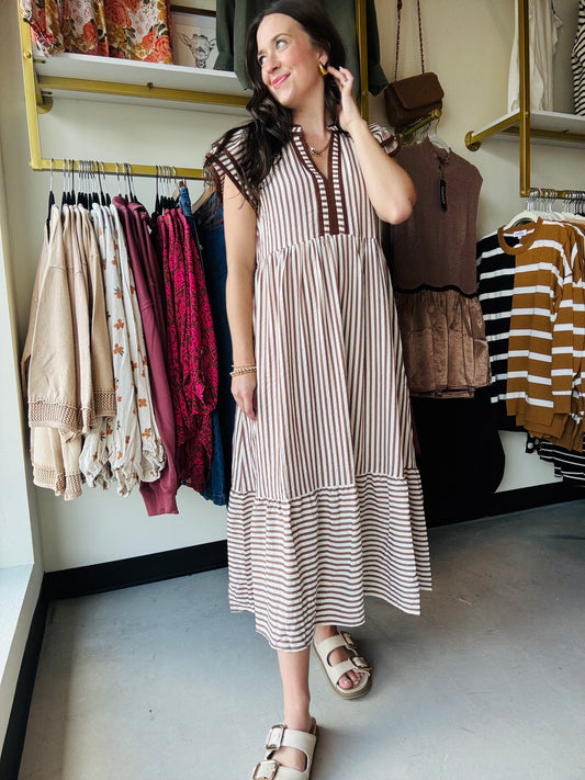 This brown cap sleeve dress features a textured striped pattern enhanced by tiered ruffle flutter sleeves with contrast accent binding detail for a refined look. Crafted from lightweight woven fabric, it offers a comfortable, non-sheer feel and includes convenient side pockets. Fully lined for added comfort and modesty, this dress combines style and functionality with expert design elements.

Entro