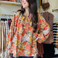 Bibi

This orange floral blouse features exaggerated balloon sleeves and a front tie detail, combining bold design with feminine elegance. Its lightweight fabric ensures comfort and breathability, while the vibrant print adds a fresh, stylish touch to any outfit. Ideal for elevating both casual and dressier looks with a confident, expert flair.