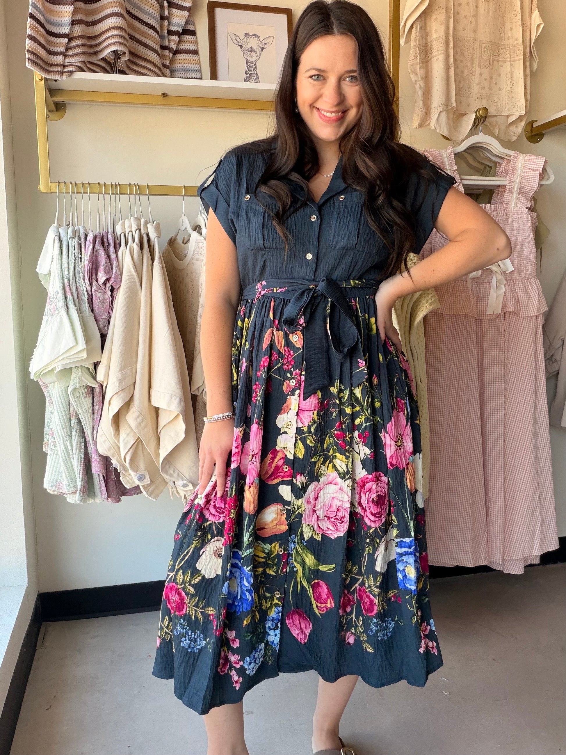 Navy Mix Floral Tie Waist Dress

A print-forward dress that means business — in the best way. This floral shirt dress features a flattering tie waist, bronze button details, and cuffed roll sleeves for a polished yet relaxed look. Fully lined and crafted in a flowy rayon blend, it transitions effortlessly from a day out to an evening event.

Floral print on a navy mix base
Shirt dress silhouette with tie waist
Bronze button details down the front
Cuffed roll sleeves
Fully lined
83% Rayon, 17% Nylon — lightw