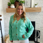 This Green Wave Detail Cardigan Sweater is designed with a unique knit detail, perfect for summer layering. It features a beautiful green color and a classic button-up design. Its lightweight material makes it easy throw on for work with your white denim!