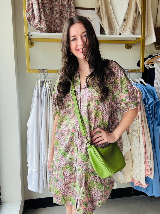 This Green &amp; Pink Floral Mini Dress features a beautiful floral print, making it a stylish and feminine choice. The V-neck and button-down design adds a touch of elegance, while the short sleeves and lightweight woven fabric make it both comfortable and fashionable. With convenient pockets and a non-sheer material, this mini dress is perfect for any occasion.