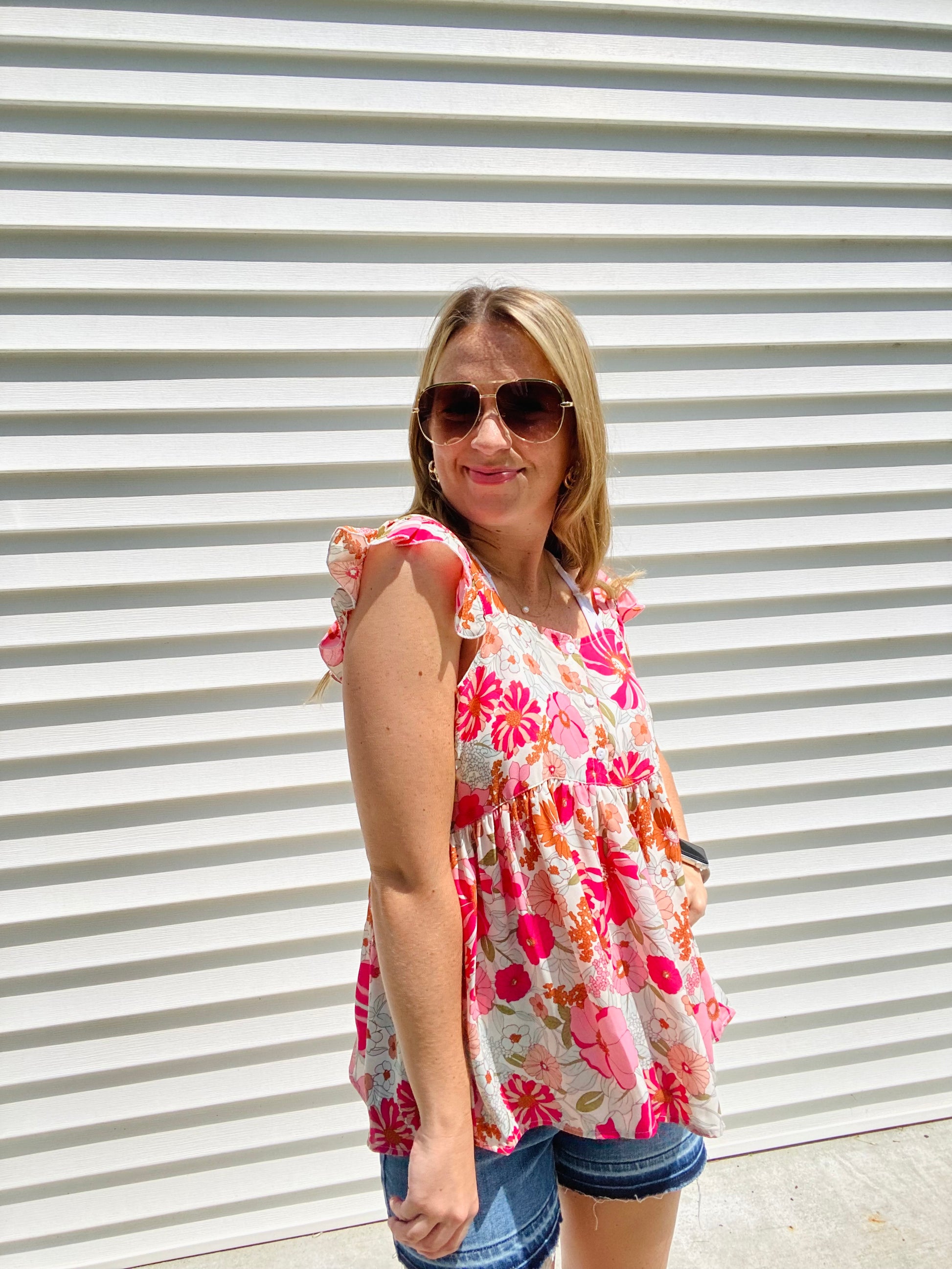This Shades of Pink Floral Top is the perfect addition to your summer wardrobe. Its high neckline and flutter sleeve are perfect for sunny days, while the bright colors and peplum top add an extra touch of style. Accessorize to create a look that is all your own.