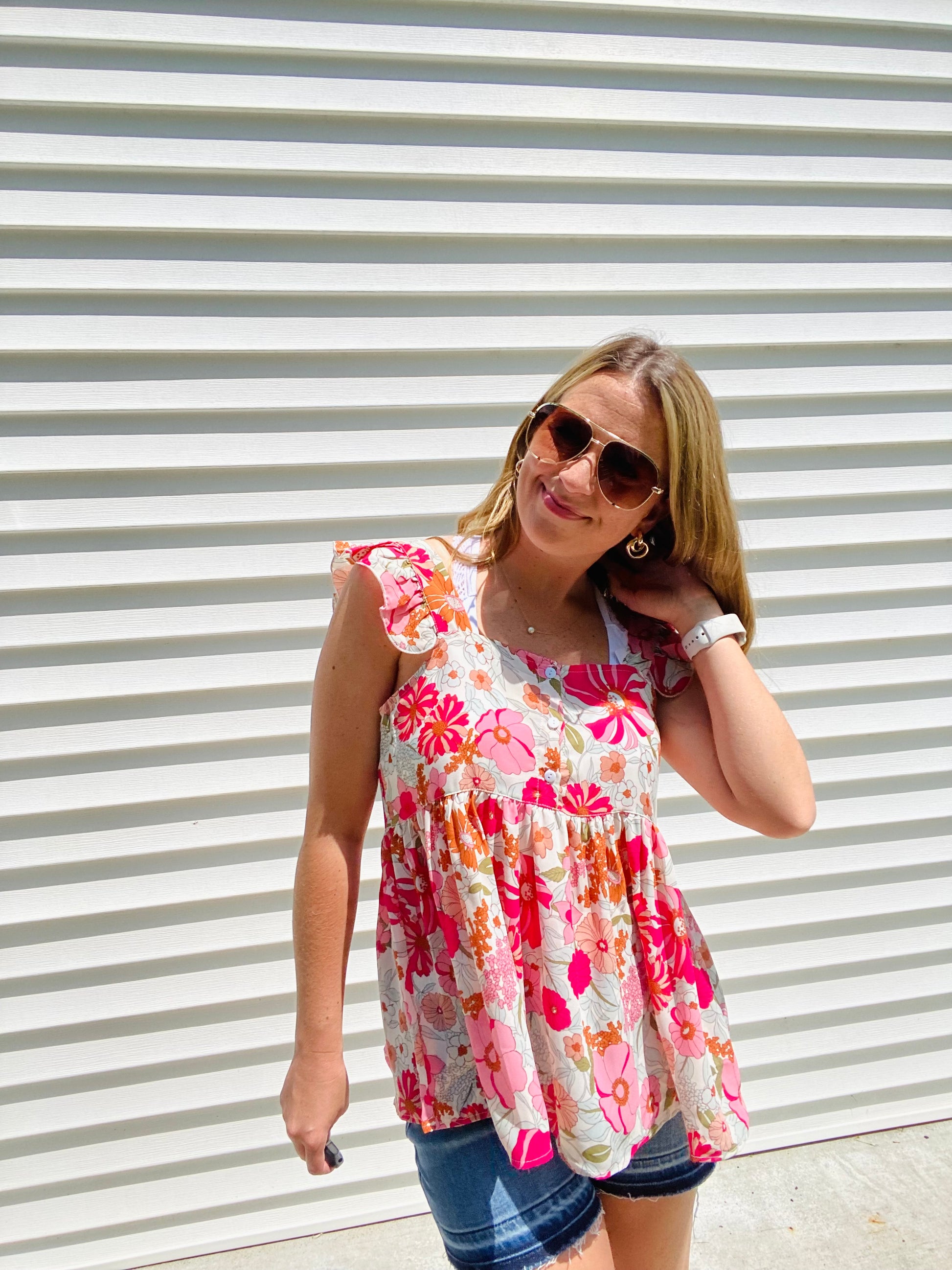 This Shades of Pink Floral Top is the perfect addition to your summer wardrobe. Its high neckline and flutter sleeve are perfect for sunny days, while the bright colors and peplum top add an extra touch of style. Accessorize to create a look that is all your own.