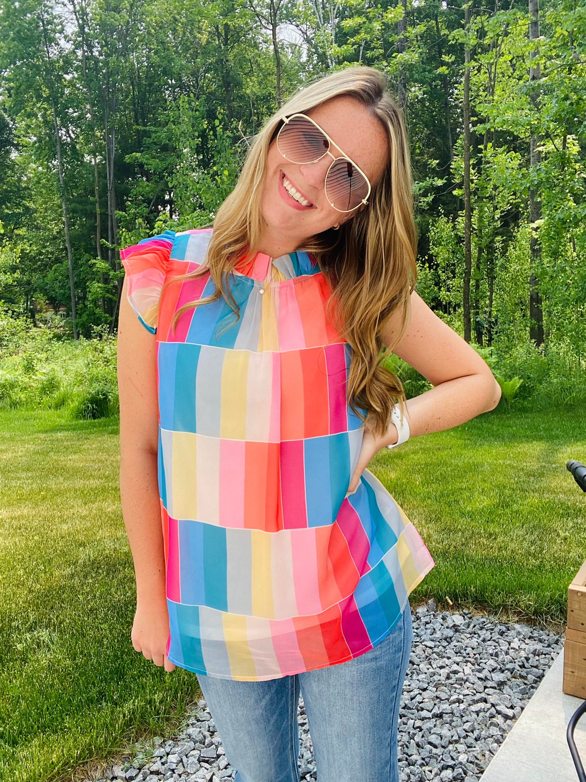 This Color Wheel Ruffle Blouse is the perfect office essential for the summer season. Crafted with bright, vibrant colors, the trendy high neckline and key hole closure provide an updated classic silhouette. The perfect match for any summer ensemble.