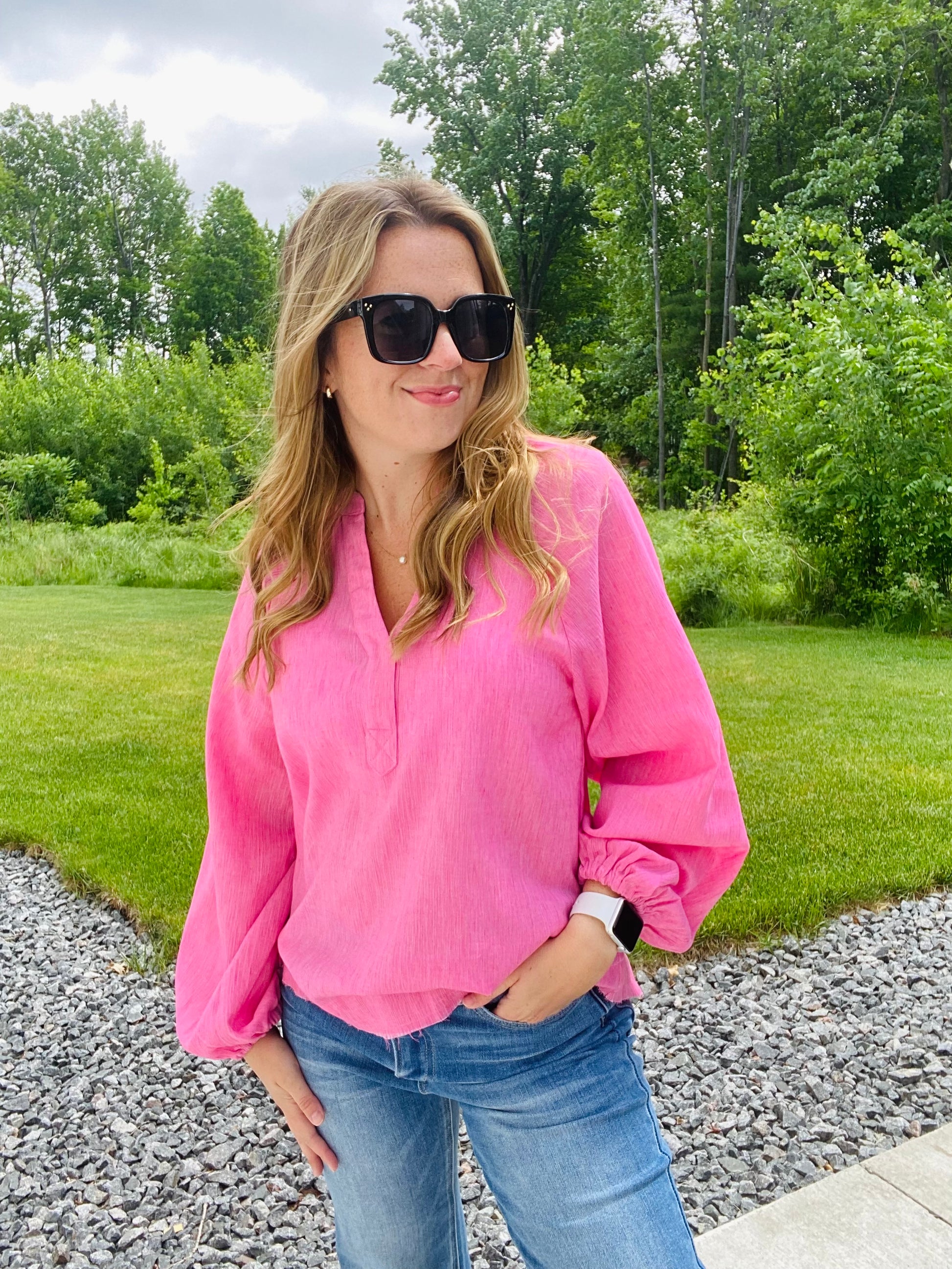 Introducing the Bubblegum Pink Woven Gauze Blouse, a stylish piece featuring V Neck Placket with Snap Closure, Raw Cut Edge Hem with Facing, Raglan Cut Bubble Sleeves, Gathered Neckline, Elasticized Wrists, and a Banded Collar. This garment is crafted with superior materials for a comfortable, timeless look.