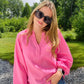 Introducing the Bubblegum Pink Woven Gauze Blouse, a stylish piece featuring V Neck Placket with Snap Closure, Raw Cut Edge Hem with Facing, Raglan Cut Bubble Sleeves, Gathered Neckline, Elasticized Wrists, and a Banded Collar. This garment is crafted with superior materials for a comfortable, timeless look.