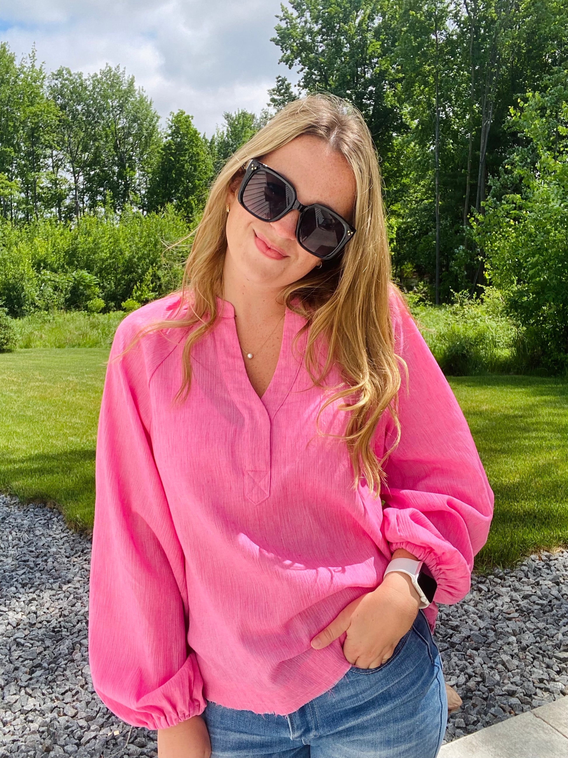 Introducing the Bubblegum Pink Woven Gauze Blouse, a stylish piece featuring V Neck Placket with Snap Closure, Raw Cut Edge Hem with Facing, Raglan Cut Bubble Sleeves, Gathered Neckline, Elasticized Wrists, and a Banded Collar. This garment is crafted with superior materials for a comfortable, timeless look.