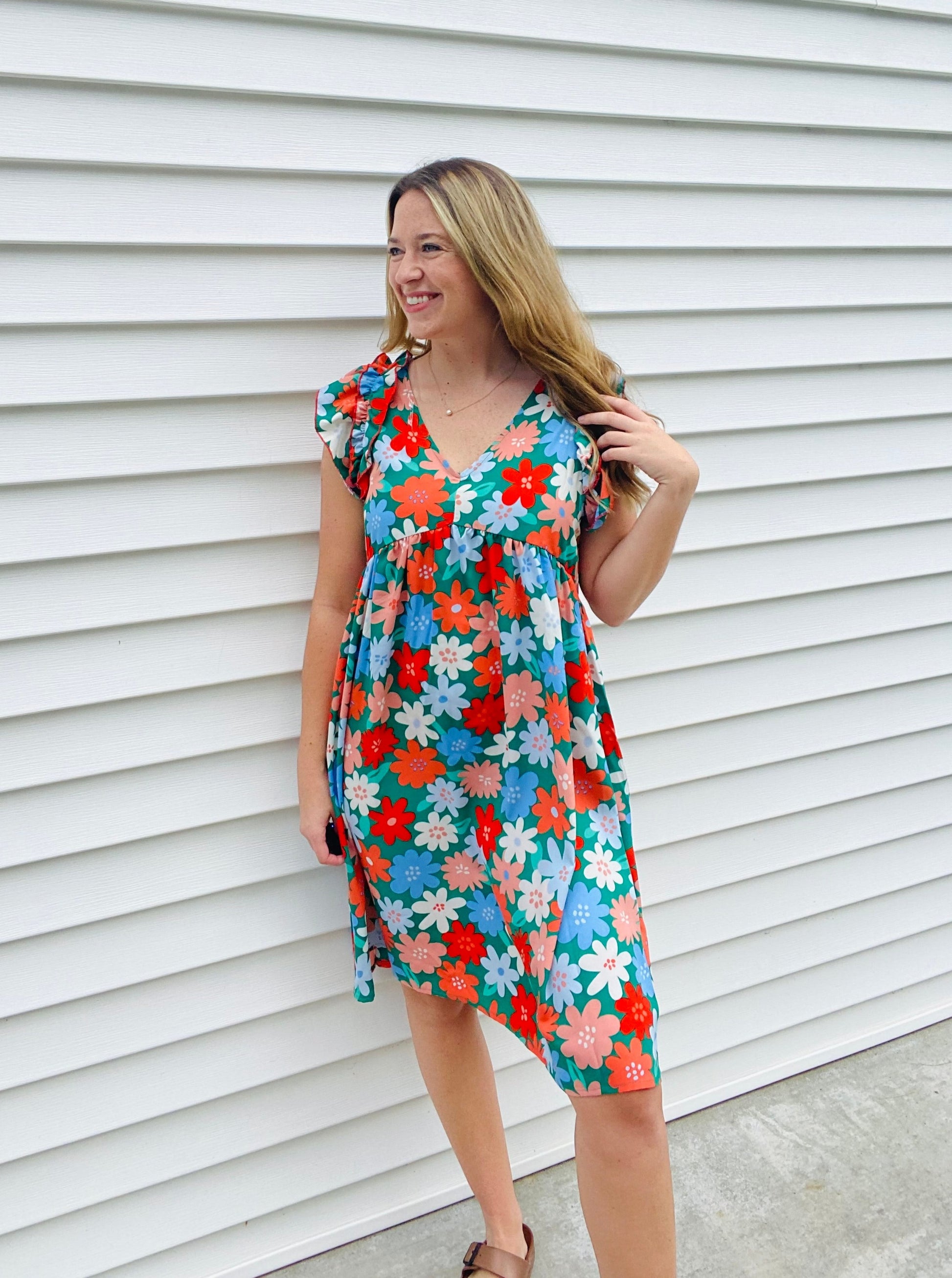 This V-neck babydoll dress flaunts a charming double frill ruffle yoke and is adorned with a multicolor floral challis print. Crafted from a lightweight woven fabric, it features modest short sleeves, side pockets, and a flattering midi length shift silhouette. A beautiful addition to your wardrobe.