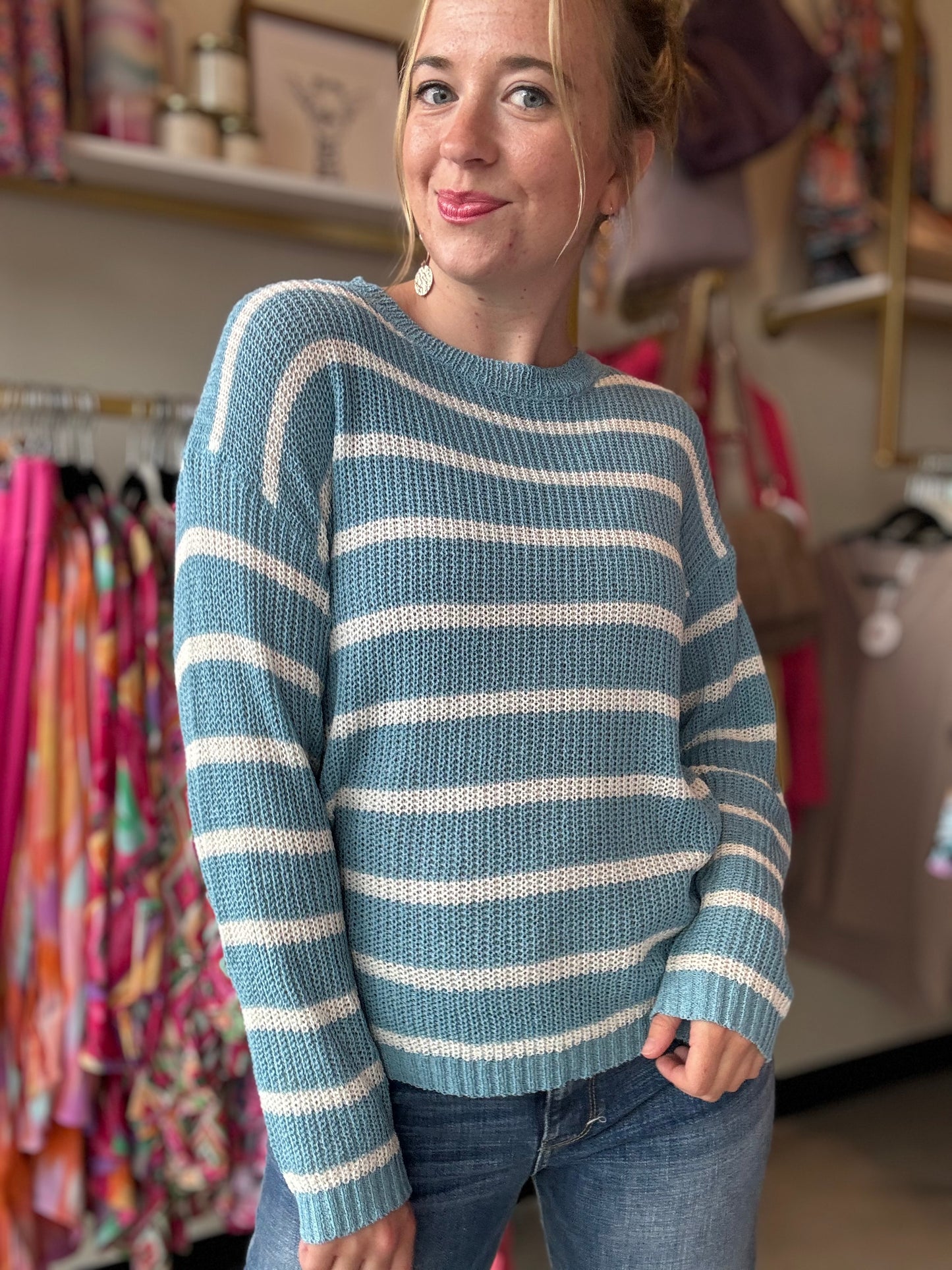 Transition from summer to fall in style with our Blue and White Summer Sweater. This lightweight sweater boasts a beautiful low gauge texture and a slouchy fit for a fun and playful look. Perfect for those chilly nights, this striped sweater is a must-have for any wardrobe.  Bibi Brand