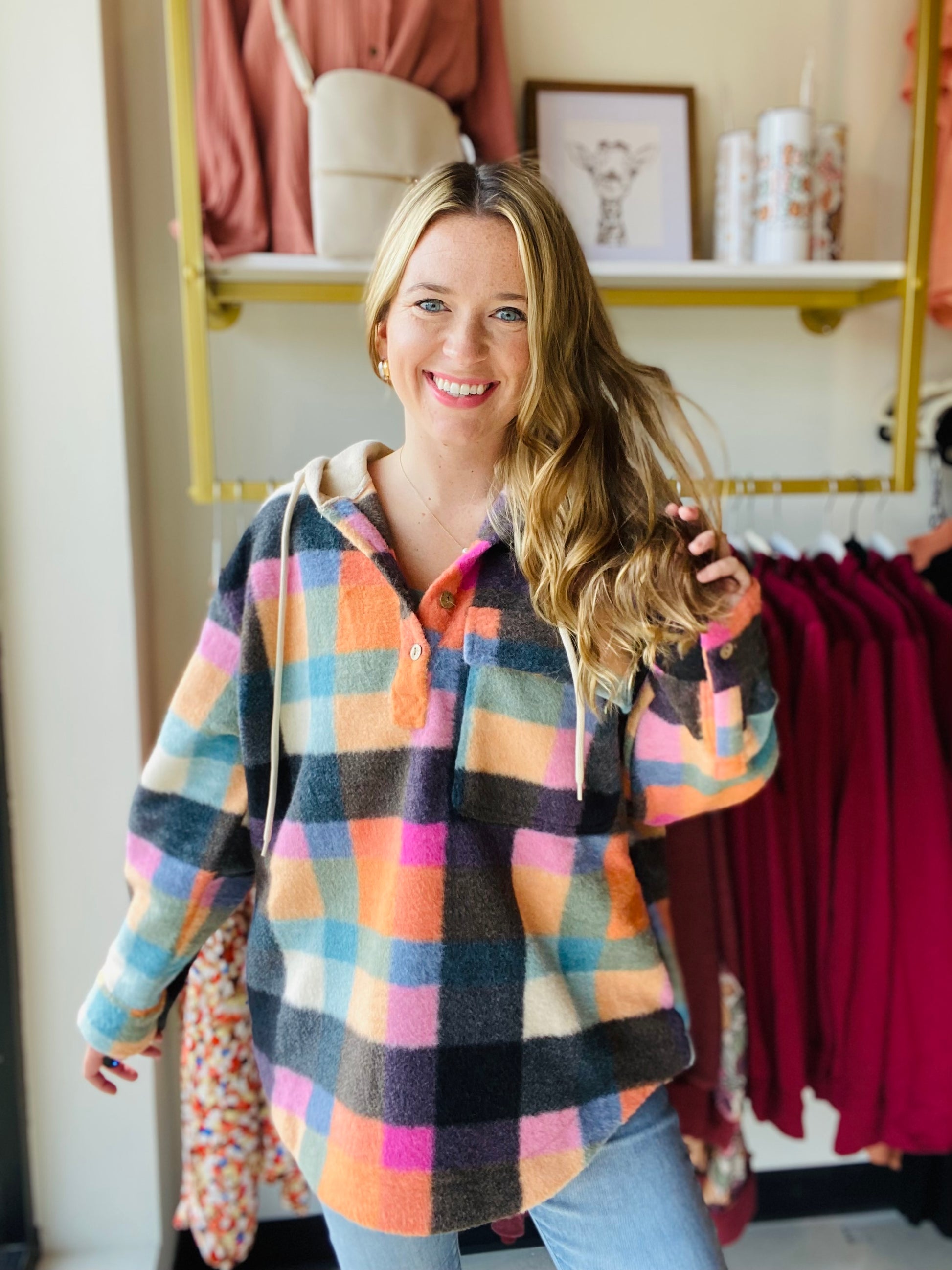 This Multi Checker hoodie is sure to be a must-have for the season! It comes in trending colors for fall and is made of brushed fleece with functioning buttons and a breast pocket. The oversized fit gives a comfortable and relaxed look. Stay warm and fashionable with this stylish hoodie.  Bibi Brand