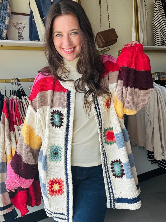 POL

Cozy up in the Ivory Multi Crochet Sweater, featuring an open cardigan style and fun balloon sleeves for an effortlessly oversized look. Crafted from soft chenille, it’s topped with a charming handmade patch and a pointed striped pattern that adds a playful twist to your everyday outfit. Perfect for layering and bringing joy to cooler days!