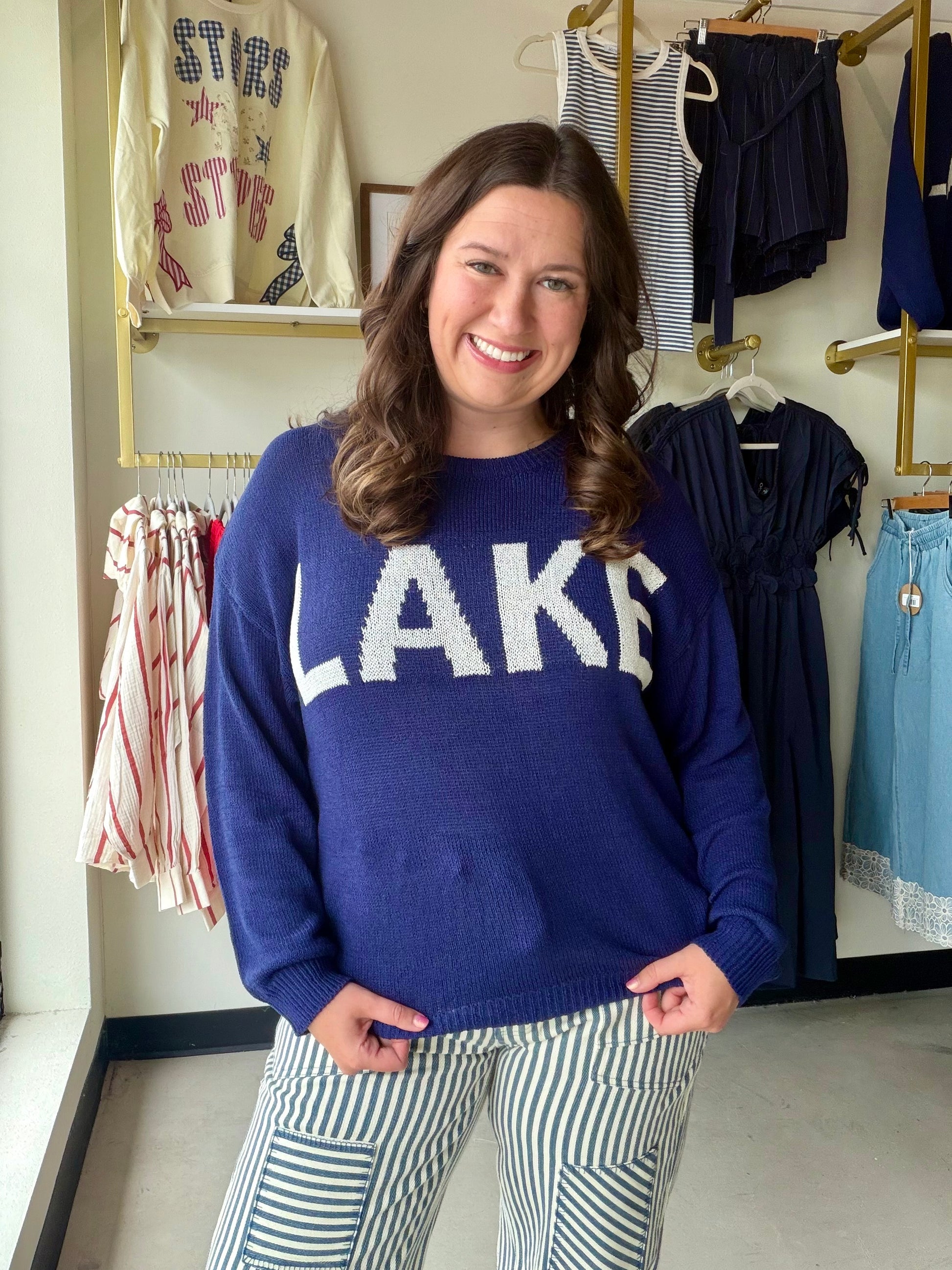 Jess Lea

Brighten your wardrobe with this breezy lightweight sweater in navy blue, featuring eye-catching white lettering that adds personality and charm. Perfect for layering on mild days or wearing solo when the weather's just right, this piece strikes the ideal balance between comfort and style. The playful color combo makes it a versatile go-to that pairs effortlessly with your favorite jeans, skirts, or casual bottoms. Lightweight enough for spring strolls and cozy enough for cool evenings—your new fa